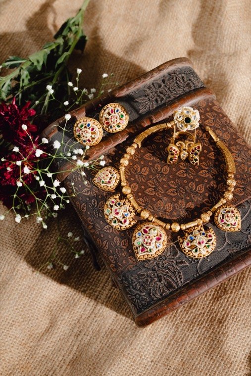 Antique necklace and earrings resting on a carved wooden box